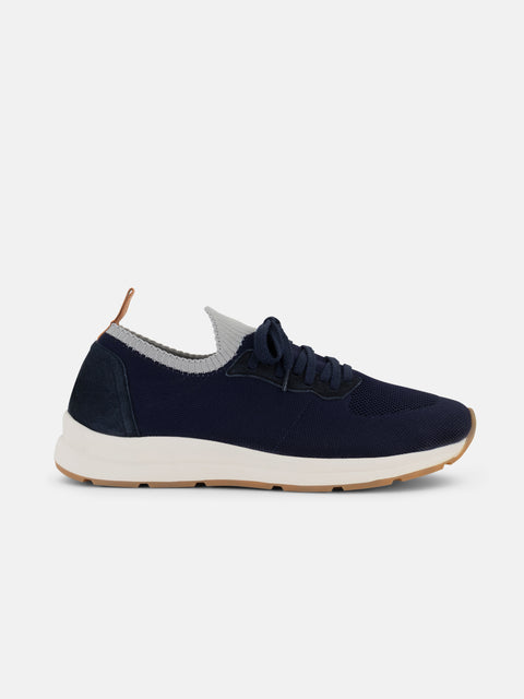 Navy blue sneaker with white sole on a light gray background